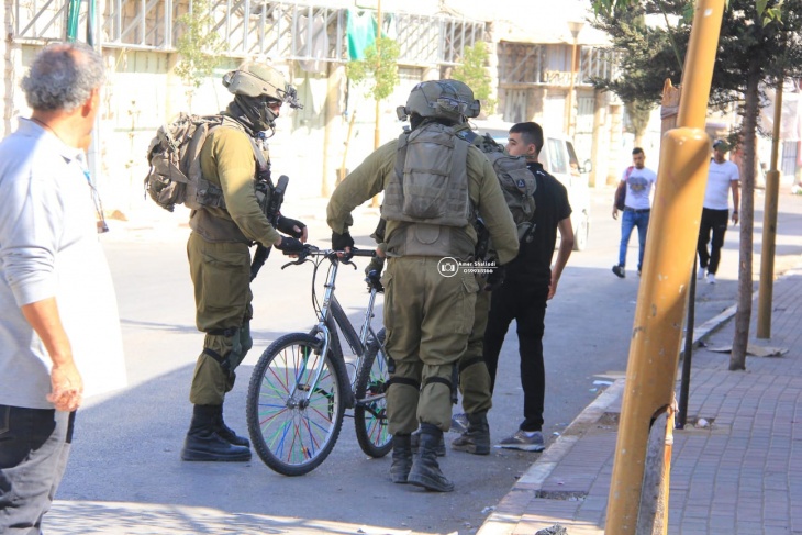 Photos: The occupation forces arrest a child and confiscate his bicycle in Hebron