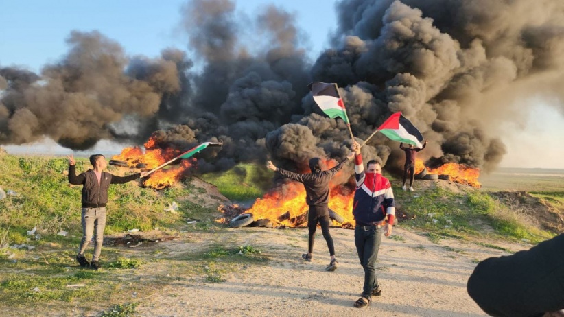 Young men burn tires near the eastern border of Gaza